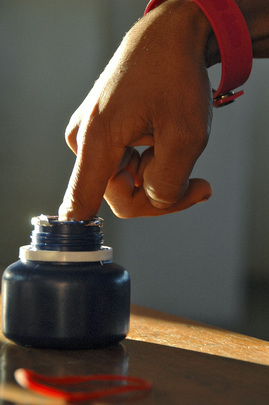 Elections in East Timor: a voter dips his finger in an ink bottle after voting in the election.