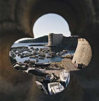 Scorcio di Dubrovnik attraverso un'apertura a forma di fiore, coinvolta nel conflitto dei Balcani.