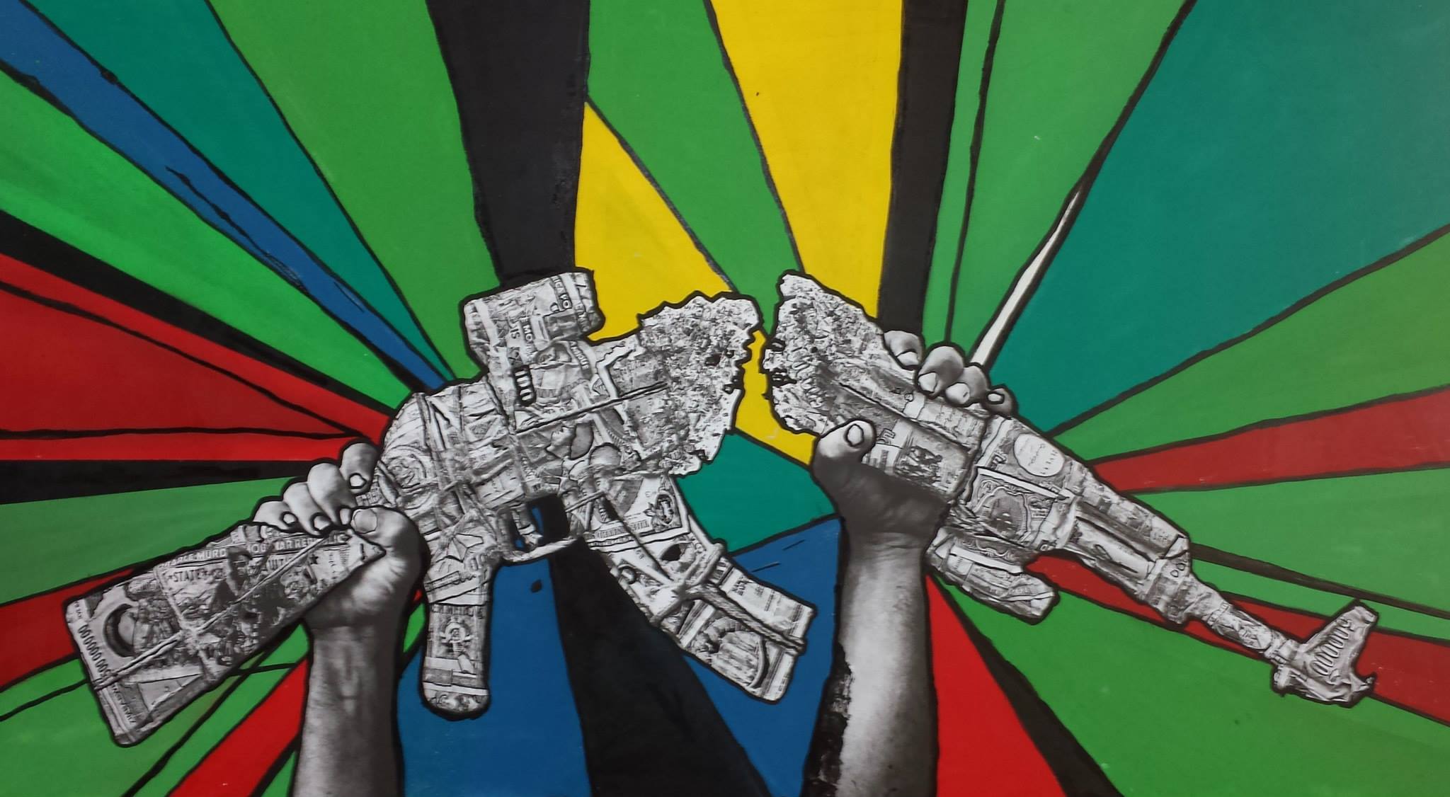 A gun made of cash is broken in half, on a multicoloured background