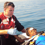 An unidentified Coast Guard crew member aboard the Coast Guard Cutter Tahoma provides medical aid to an evacuated Haitian