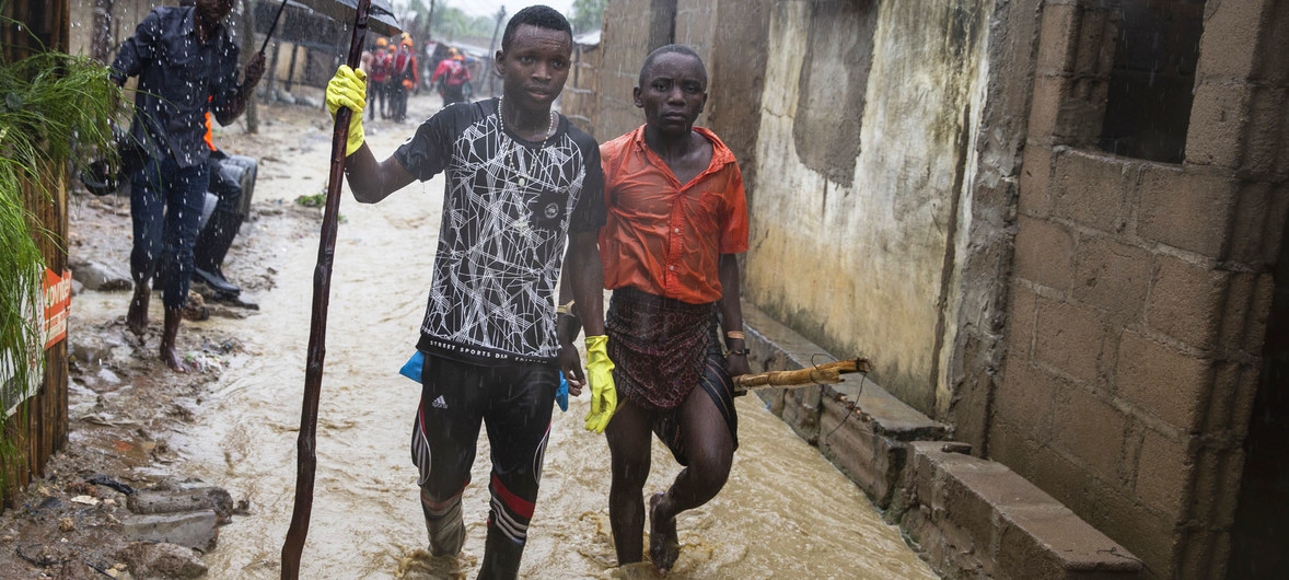 Due giovani uomini durante l'alluvione dell'area di Shababuri nel Pemba in Mozambico, dopo una forte pioggia (Aprile 2019). 