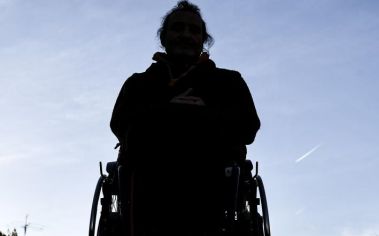 Una persona in sedia a rotelle in controluce