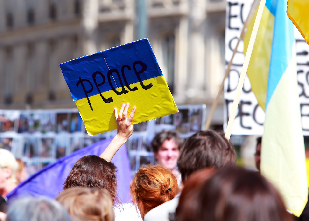 Segno di pace sulla bandiera ucraina in manifestazione di protesta contro la guerra in Ucraina in Piazza della Repubblica di Parigi il 02 agosto 2014 a Parigi, Francia