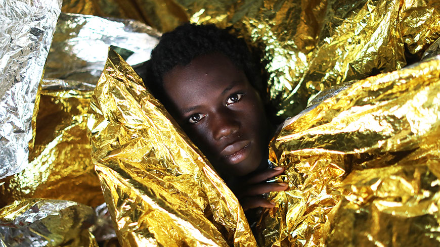 Bambino migrante della Guinea con coperte termiche a seguito di un'operazione di salvataggio in mare da parte di una ONG spagnola