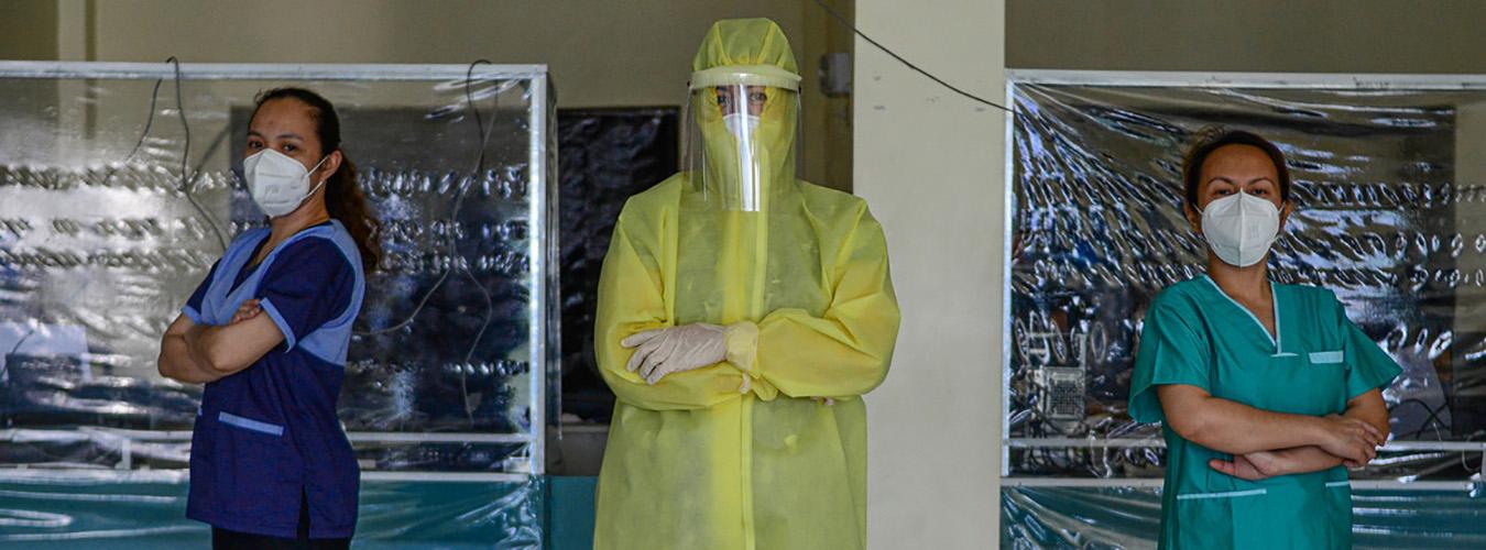 L'immagine mostra una dottoressa e due volontarie che indossano mascherine e tute protettive anti contagio in un ospedale nelle Filippine