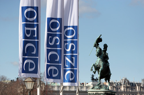 Bandiere contenenti il logo dell'OSCE in russo, inglese e tedesco di fronte al Palazzo dell'Hofburg a Vienna