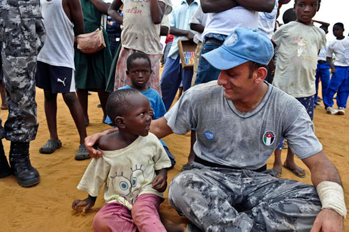 Un Peacekeeper delle Nazioni Unite parla con un bambino 