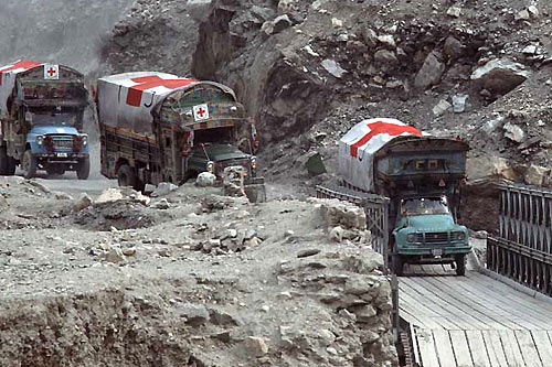 Camion della croce rossa in fila in una zona di conflitto