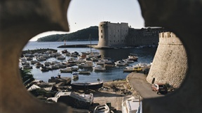 Scorcio di Dubrovnik attraverso un'apertura a forma di fiore, coinvolta nel conflitto dei Balcani.