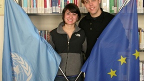 I due ragazzi, Lani e Ryan, nella biblioteca del Centro diritti umani tengono in mano le bandiere delle Nazioni Unite e dell'Unione Europea.