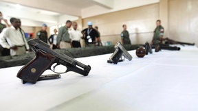 Su un tavolo alcune delle dieci armi consegnate volontariamente da alcuni membri di una gang di Port-Au-Prince, Haiti.