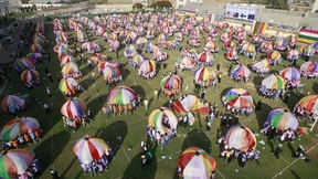 Durante la celebrazione dell'ultimo giorno dei Giochi estivi di quest'anno, 3.500 bambini delle scuole di Gaza intendono battere il guiness dei primati giocando con 157 paracaduti colorati giganti, allo stadio Khan Younis. Ogni paracadute è tenuto da 20 bambini. 