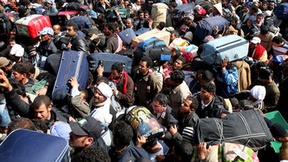 Thousands of people with packanges and bags try to leave Libya at the Tunisian border