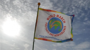 Una bandiera con il logo della Marcia Mondiale per la Pace e la Nonviolenza