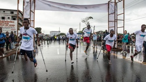Atleti disabili si spingono in avanti alla partenza della Maratona in Liberia per persone con disabilità. 