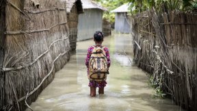 Una bambina va a scuola durante l'alluvione (Bangladesh)