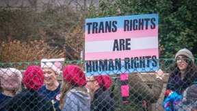People participating Women's March in Washington D.C. holding a sign written: Trans Rights are Human Rights.