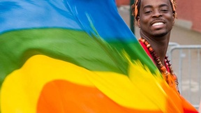 Un attivista sventola una bandiera arcobaleno, il simbolo internazionale dei diritti degli omosessuali