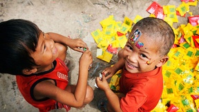 Due bambini giocano con l'immondizia e con adesivi colorati