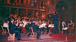 Photo taken at the concert: "Musiche per una professione di pace," or Music for a Profession of Peace. Venice, St. Mark's Basilica, 23 May 1991. In the photo one can observe the conductor directing the orchestra.