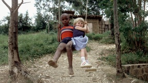 Due bambini di diversa razza giocano insieme in altalena