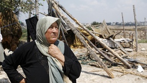 Una donna libanese osserva i resti del proprio villaggio distrutto dai bombardamenti avvenuti durante il conflitto