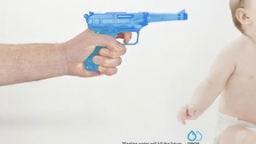 L'immagine raffigura una pistola ad acqua puntata alla testa di un neonato