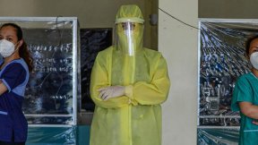 Wearing a full protective suit, a doctor leads a group of volunteer medical professionals attending to COVID-19 patients and persons under investigation at a community hospital in the Philippines.
