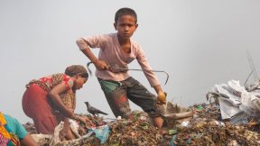 Un bambino di dieci anni lavora in condizioni pericolose e malsane in una discarica di rifiuti a Dhaka, in Bangladesh.