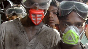 Alcuni giovani lavoratori del Bangladesh con mascherine e occhiali protettivi, con i vestiti sporchi dopo una giornata di lavoro.