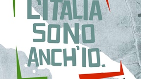 Compare la scritta grande al centro "L'Italia sono anch'io" tra parentesi quadre, rossa a destra e verde a sinistra, sullo sfondo in bianco la sagoma dell'Italia; i colori richiamano la bandiera italiana. 