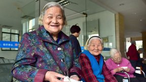 The image shows three old women in the waiting room of a hospital