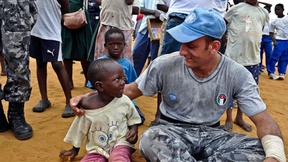 Un Peacekeeper delle Nazioni Unite parla con un bambino 