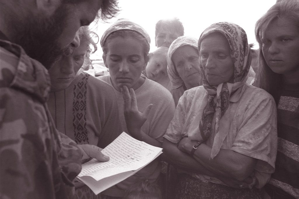 In 1995, a government soldier reads the names of soldiers who are among the survivors or escapees from the fallen city of Srebrenica