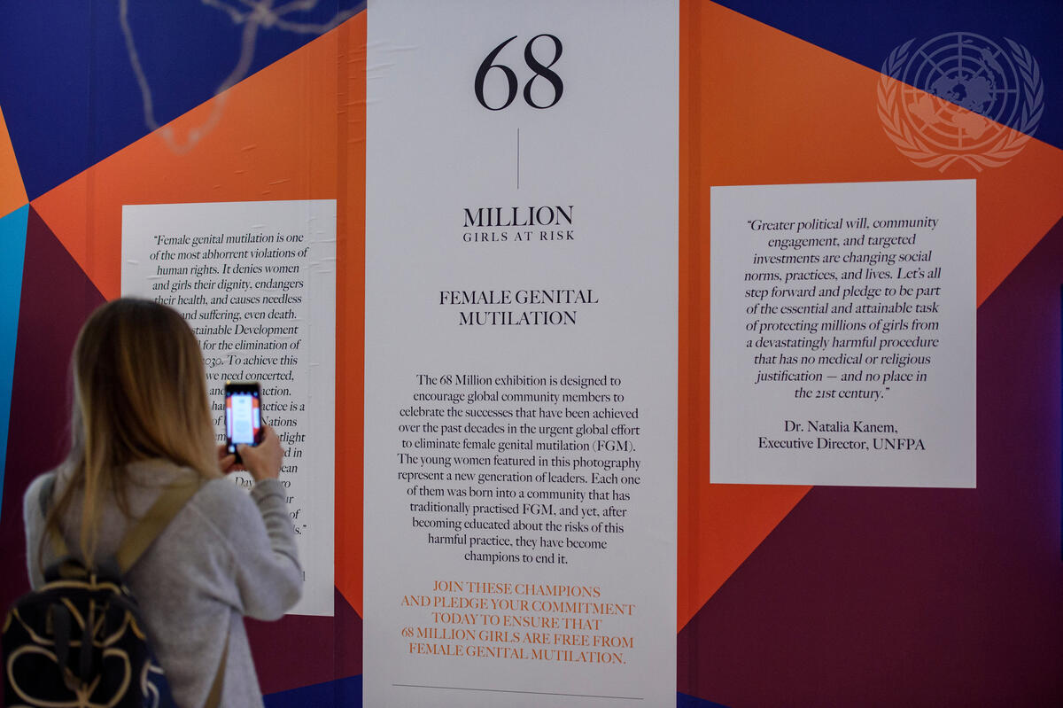 A visitor takes a photo at the opening of the photo exhibit ""The 68 Million Girls at Risk"", on the occasion of the International Day of Zero Tolerance for Female Genital Mutilation.