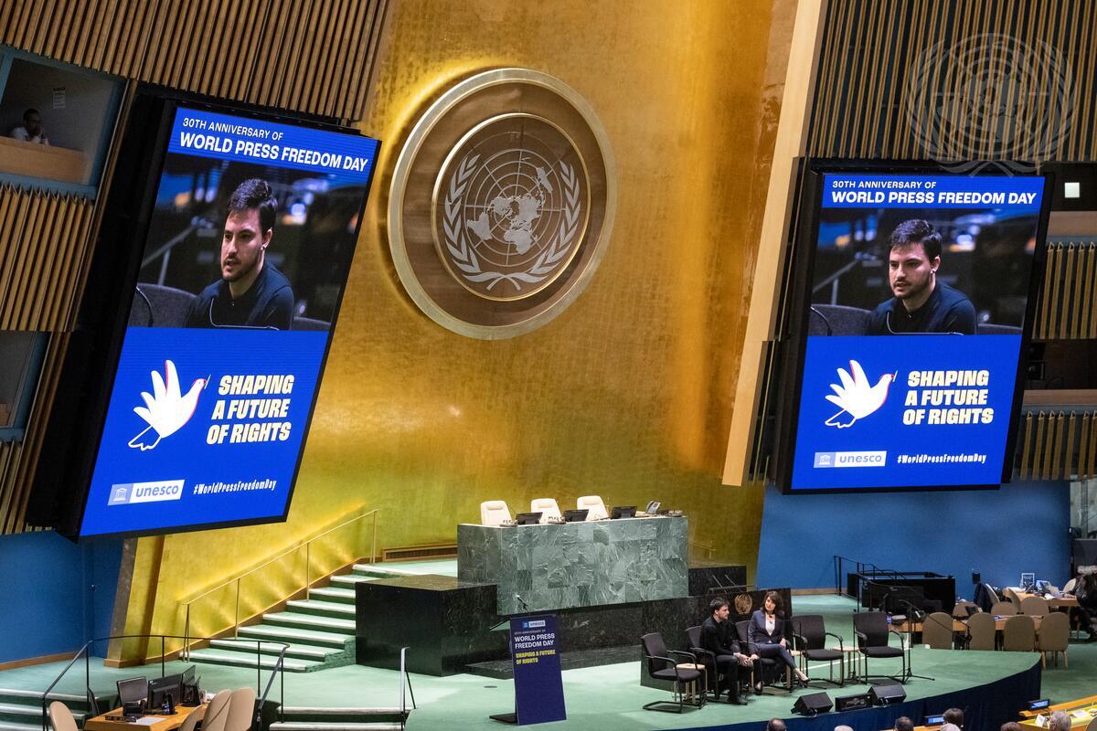 Felipe Neto (on screens and seated left at podium), Communicator and Digital Influencer, speaks during the opening of the commemoration of the 30th Anniversary of World Press Freedom Day on the theme “Shaping a Future of Rights: Freedom of expression as a driver for all other human rights”. Seated at right is Kristen Saloomey, Correspondent with Al Jazeera.
The event is organized by the United Nations Educational, Scientific and Cultural Organization (UNESCO).