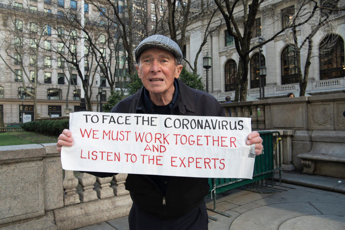 A New York City resident holds a sign with a message on how to tackle the situation during the Coronavirus (COVID-19) outbreak.