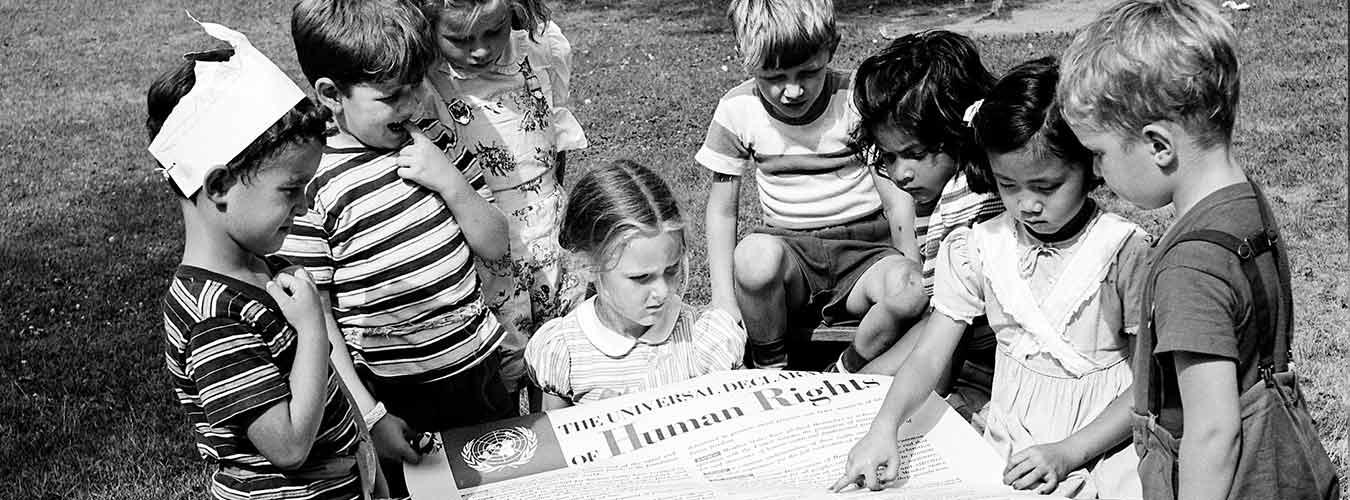 Children from the United Nations International Nursery School look at a poster of the Universal Declaration of Human Rights. (1950) UN Photo